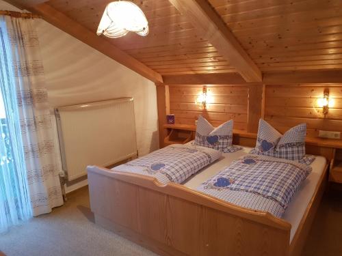 ein Schlafzimmer mit einem Bett in einem Holzhaus in der Unterkunft Ferienhaus Weps in Arnbruck
