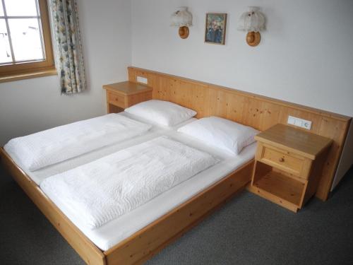 a bedroom with a wooden bed and a wooden table at Honsnhof in Tux
