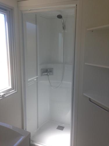 a shower with a glass door in a bathroom at DS One Vacances, Prairies de la Mer in Grimaud