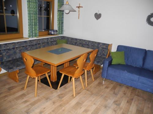 a living room with a table and chairs and a blue couch at Honsnhof in Tux