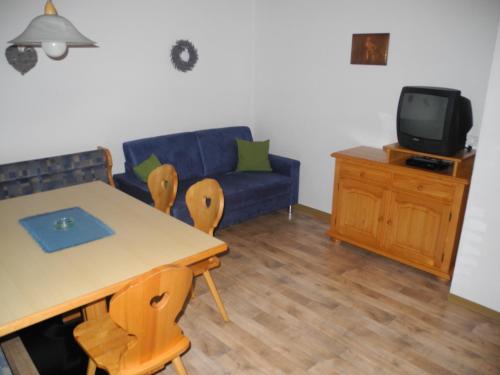 a living room with a table and a blue couch at Honsnhof in Tux