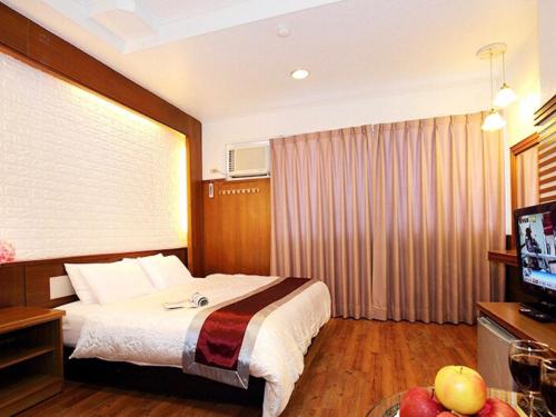 une chambre d'hôtel avec un lit et une télévision dans l'établissement 日月潭 -日月住館-休閒旅館- 水社碼頭, à Yuchi