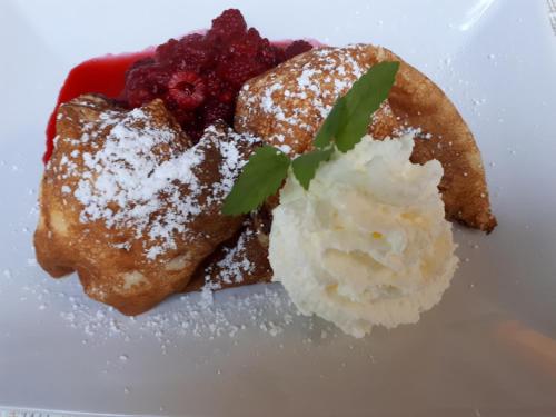 a white plate with a dessert with strawberries and powdered sugar at Forellenstube in Lofer