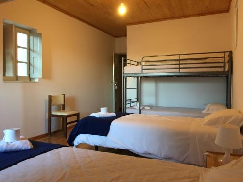 a bedroom with two beds and a bunk bed at Residencial Avenida Hostel in Tomar