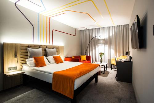 Cette chambre d'hôtel comprend un lit avec une couverture orange. dans l'établissement ibis Styles Warszawa City, à Varsovie