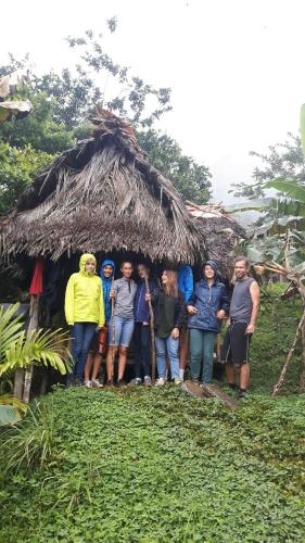 a group of people standing in front of a thatch hut at Rainforest Yasmin Hotel in Santa Fe