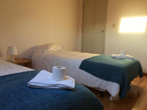 a room with two beds with towels on them at Residencial Avenida Hostel in Tomar