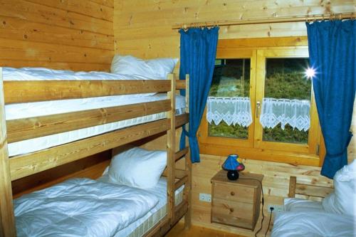 two bunk beds in a log cabin with a window at Ferienhaus Weil in Stamsried