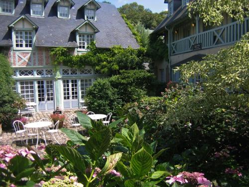 a house with a garden with chairs and flowers at Relais Hôtelier Douce France in Veules-les-Roses