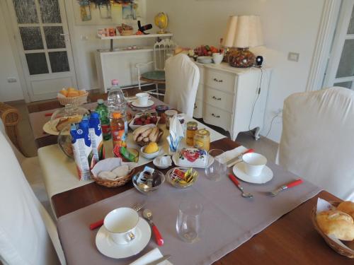 a dining room table with food on top of it at Camera con Vista in Oristano