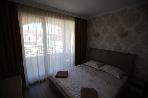 a bedroom with a bed and a large window at Apartments in RIF 3 in Ravda