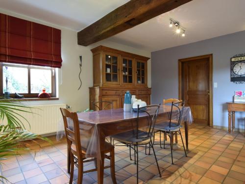 a dining room with a wooden table and chairs at Cozy Holiday Home in Noville with Private Terrace in Luzery