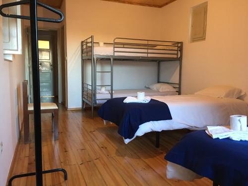 a room with two beds and a bunk bed at Residencial Avenida Hostel in Tomar
