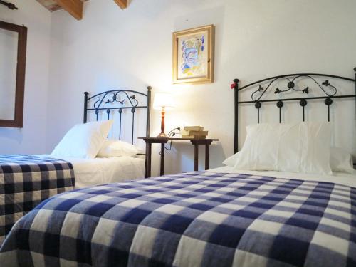 a bedroom with two beds with blue and white sheets at Villa Font March in Pollença