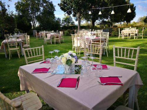 a table with red napkins and a vase of flowers on it at Podere La Branda in Vetralla