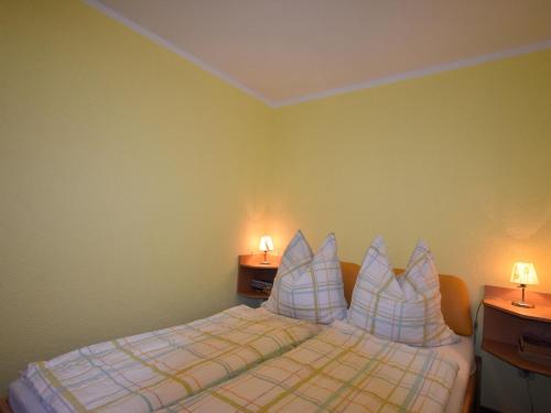 um quarto com uma cama com almofadas e 2 candeeiros em Quaint Bungalow in Reddelich near Baltic Sea Coast em Reddelich