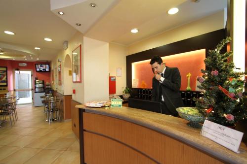 a man sitting at a bar talking on a cell phone at Hotel Della Volta in Brescia
