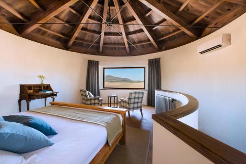 a bedroom with a bed and a table and chairs at Hotel Cortijo del Marqués in Albolote