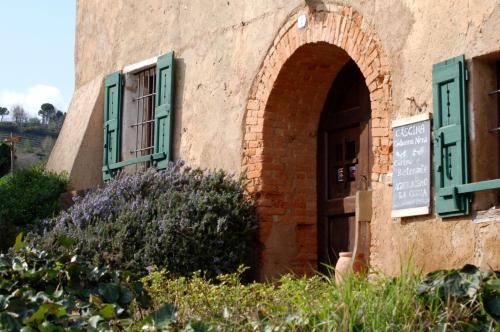 a brick building with green windows and a door at Agriturismo La Costa - Casa Vacanze in Perego