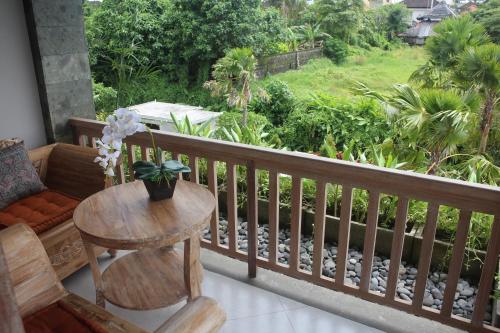 a wooden balcony with a table and a chair at Betutu Bali Villas in Ubud