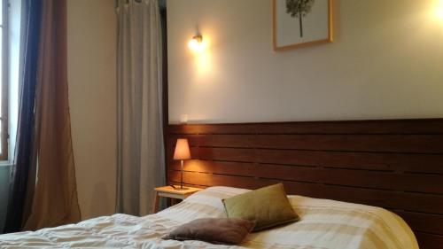 a bedroom with a bed with a wooden headboard at Hôtel de Valdeblore in Valdeblore