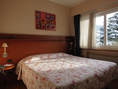 a bedroom with a bed and a window at Hotel Ristorante Fatur in Cisano Bergamasco