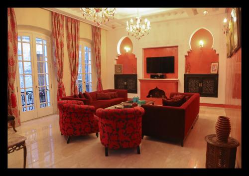 a living room with red furniture and a fireplace at Dar Souran in Tangier