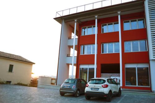 two cars parked in front of a red building at Il Sorriso in Negrar