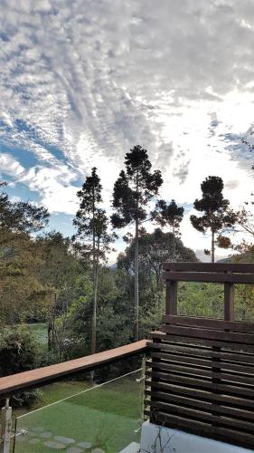 a wooden bench sitting on top of a balcony at Around The Tree Manor in Shitan
