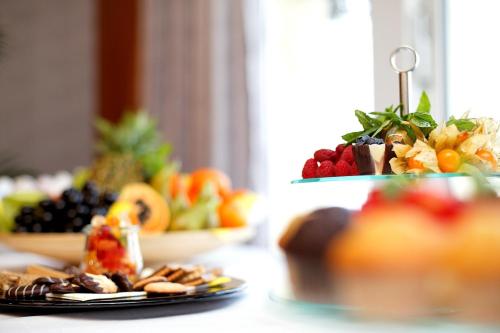 a table topped with plates of fruit and snacks at Rheinhotel Vier Jahreszeiten Bad Breisig in Bad Breisig