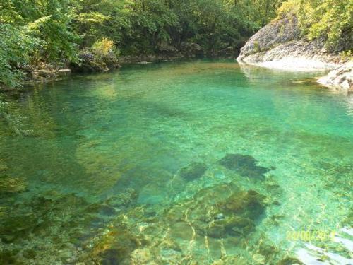 a river with clear blue water and rocks at Hotel Ladias in Monodendri