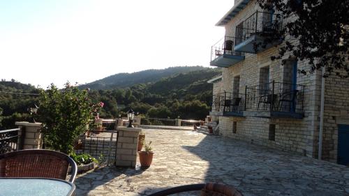 a patio of a building with a table and chairs at Hotel Ladias in Monodendri