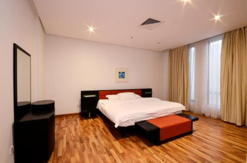 Un dormitorio con una cama blanca y suelo de madera. en Code Housing - Farms Fintas - Family Only, en Kuwait