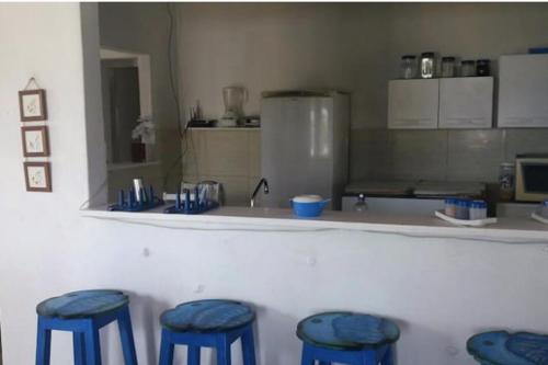 a kitchen with four blue stools in front of a counter at A 2 passos do paraíso in Rio Tinto