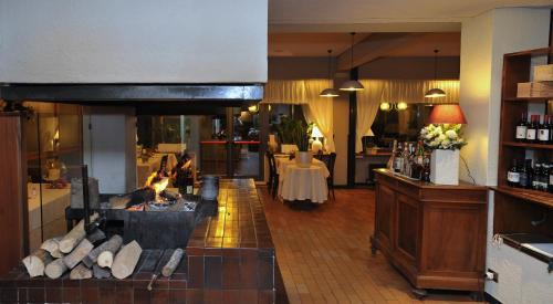 a room with a fireplace and a table in a room at Hotel Ristorante Fatur in Cisano Bergamasco