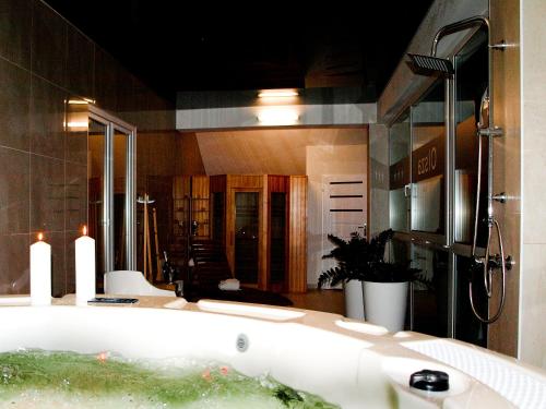 Hotel Olsza في Olszówka: حمام مع حوض استحمام مع مرآة كبيرة