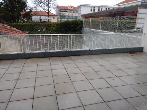 einen weißen Zaun neben einer gefliesten Terrasse in der Unterkunft ML Apartments Almirante in Porto