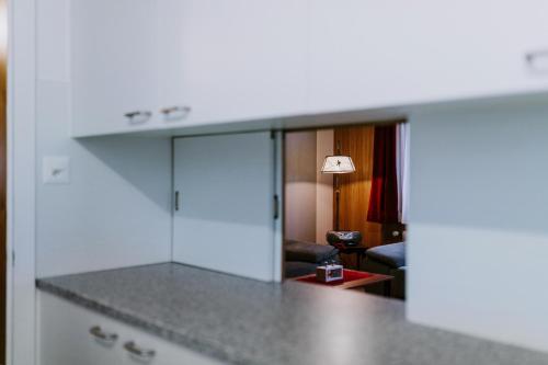 a kitchen with a counter top and a living room at Chalet Aloa in Adelboden