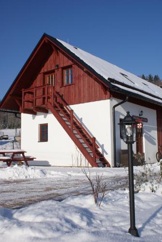 a red and white building in the snow at Guest House K74 in Jablonné v Podještědí