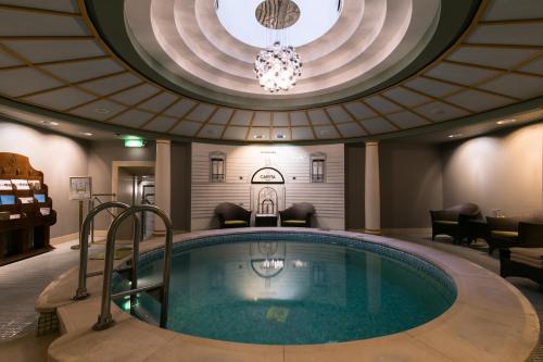 
a large swimming pool with a large mirror in the middle of it at Grand Hotel Europe, A Belmond Hotel, St Petersburg in Saint Petersburg
