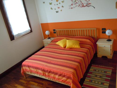 a bedroom with a bed and two night stands and a window at Il Farfasole in Vigonovo