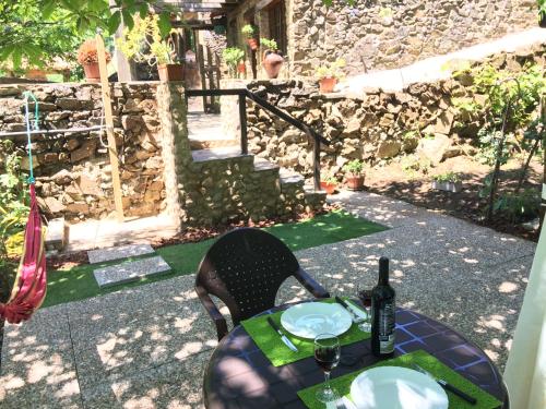 a table with two plates and a bottle of wine at Casa em Xisto na Serra da Lousã, Gondramaz in Gondramaz