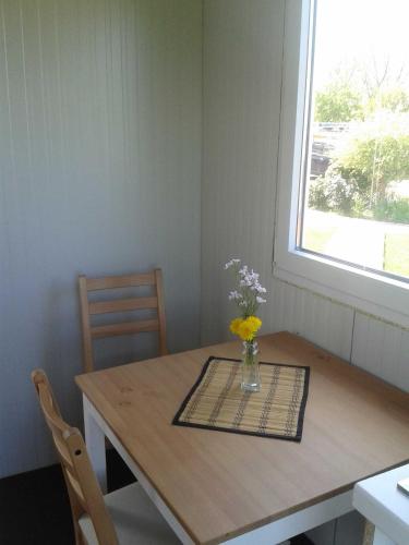 a dining room table with a vase of flowers on it at Luxus Chalet mit Terrasse, sehr ruhig in Kollmar in Kollmar