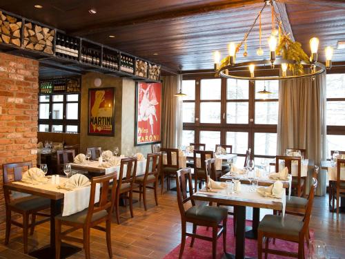 Un comedor con mesas y sillas y una lámpara de araña. en Hotel Marmore, en Breuil-Cervinia