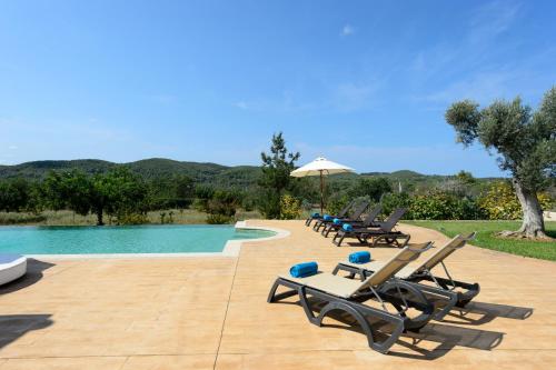 a group of lounge chairs sitting next to a swimming pool at Villa Luna in Sant Joan de Labritja