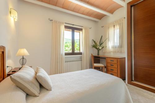 a bedroom with a white bed and a window at Villa Luna in Sant Joan de Labritja