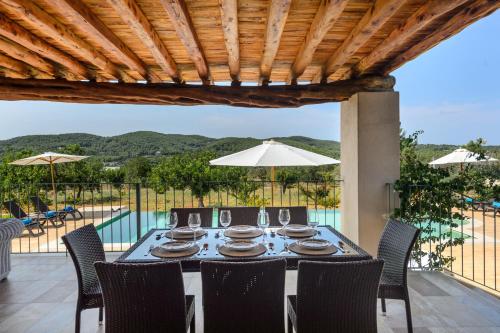 a dining room with a table and chairs and a pool at Villa Luna in Sant Joan de Labritja