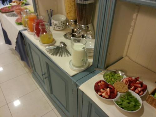 a kitchen with two counters with bowls of food and drinks at Hotel Il Gatto in Rapallo
