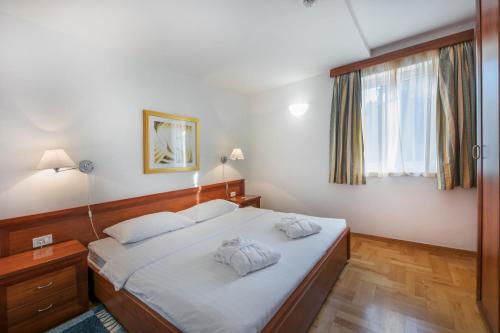 a bedroom with a bed with two pillows on it at Apartments Punta in Veli Lošinj