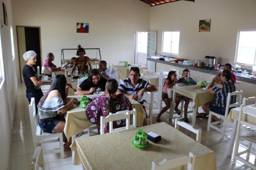 a group of people sitting at tables in a room at Pousada Sol Nascente in Piranhas